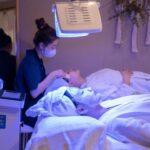 LED Light Therapy di Rumah: Aman Nggak untuk Semua Jenis Kulit? Patients receiving LED light therapy and facial treatment in a spa setting.